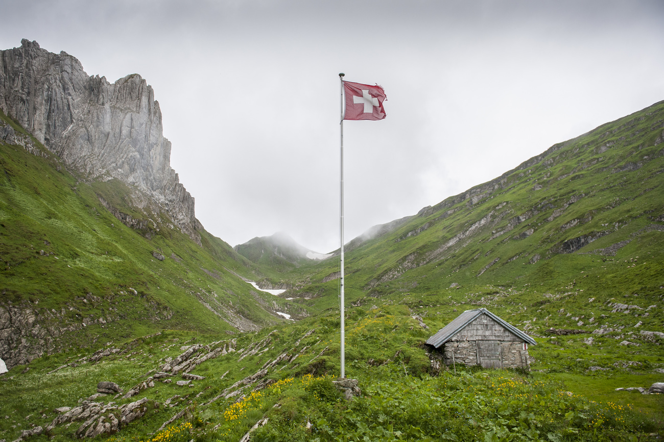 Schweizer Flagge in bedrohlicher Bergkulisse.