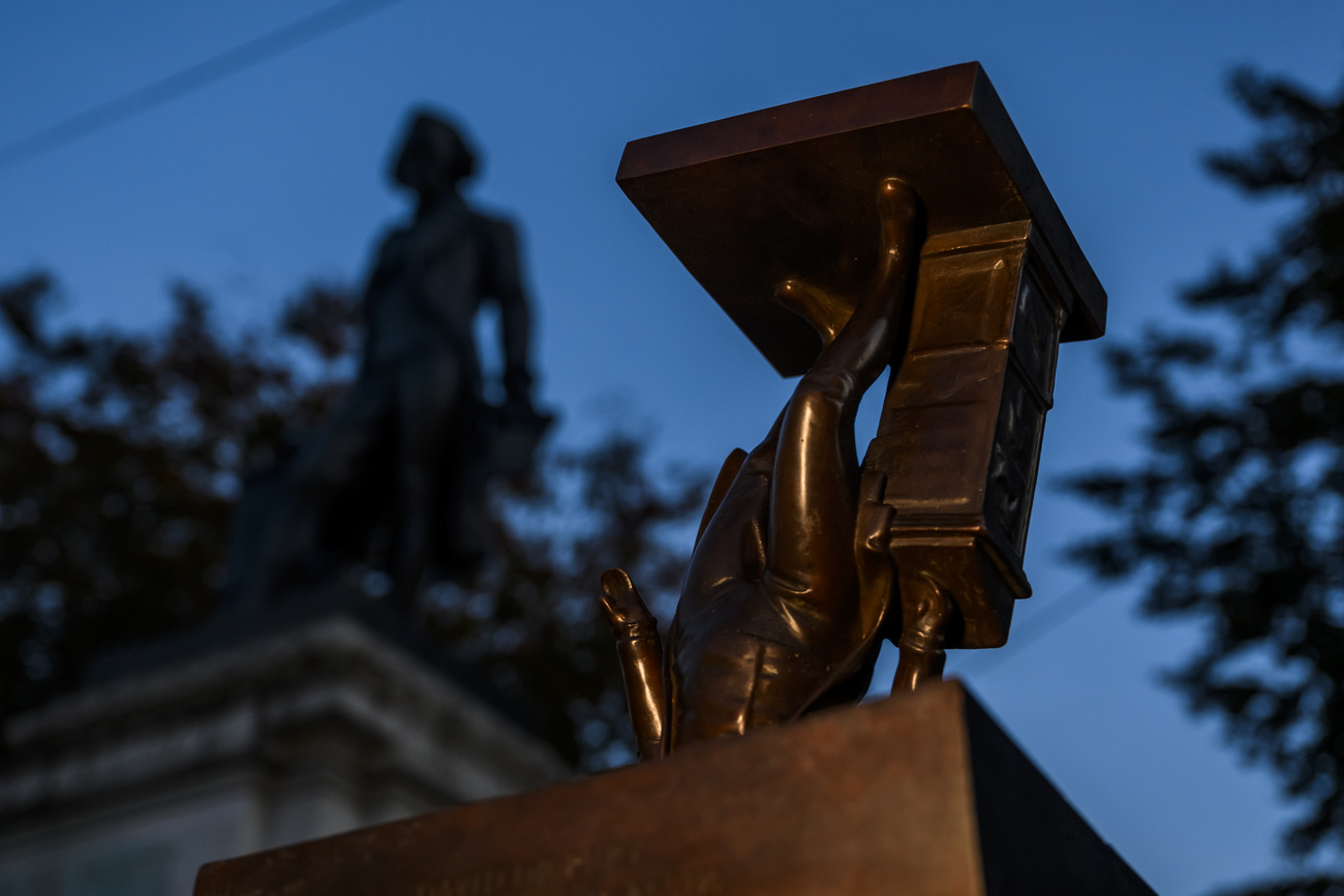 an artwork stands next to a statue