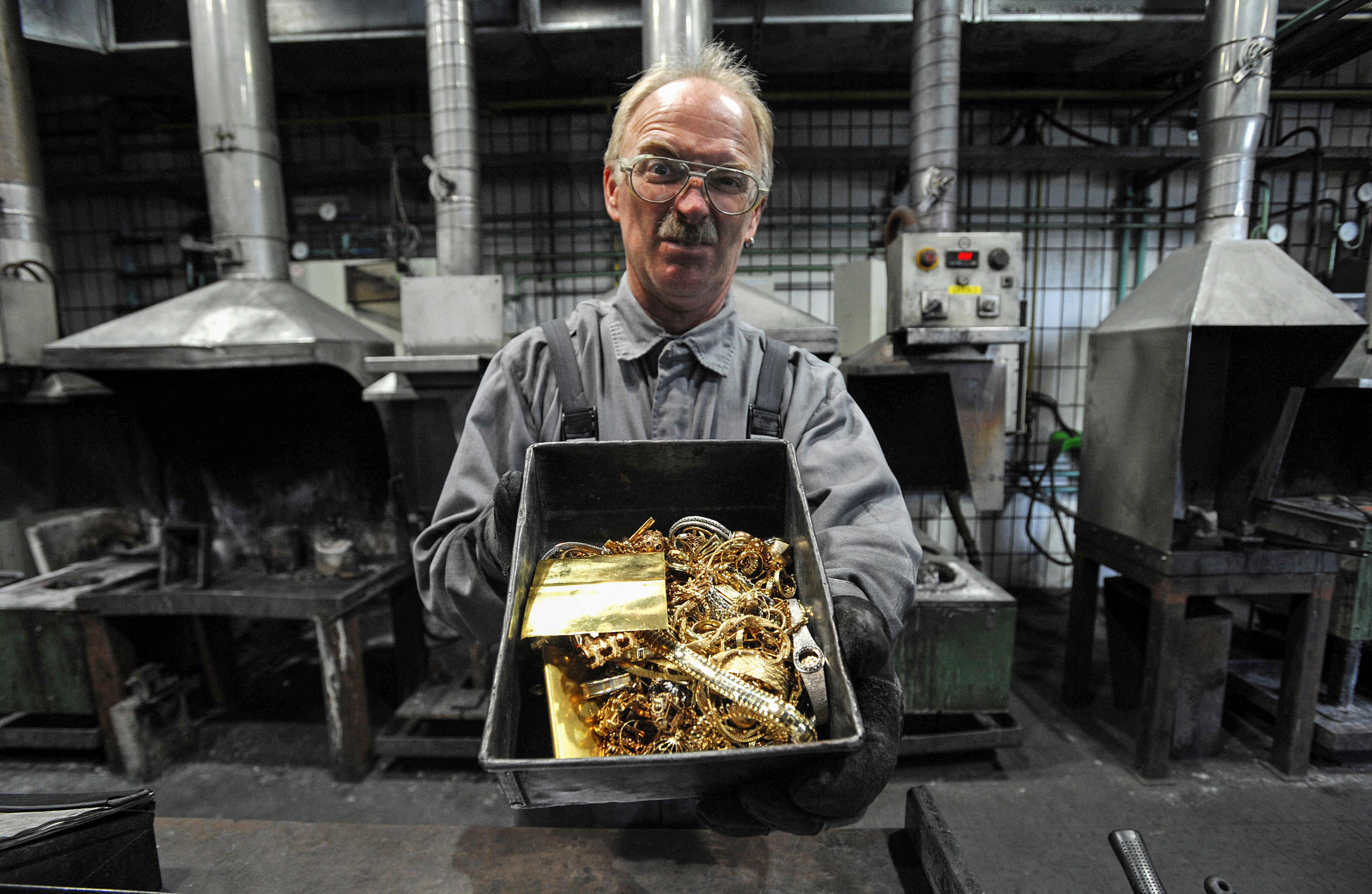 我们购买的黄金从哪儿来？这名奥地利工人手中的盒子里装着回收的首饰与旧黄金，之后它们会被熔成金条。