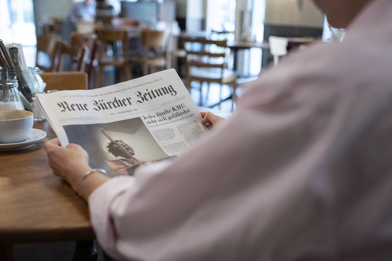 Person reading NZZ newspaper
