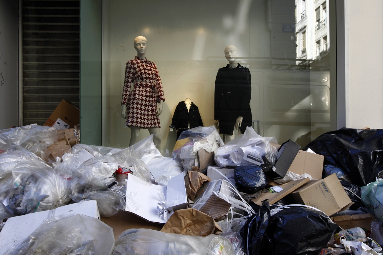 tienda de ropa aparentemente de lujo con miles de cajas de cartón y bolsas de ropa desechada delante del escaparate