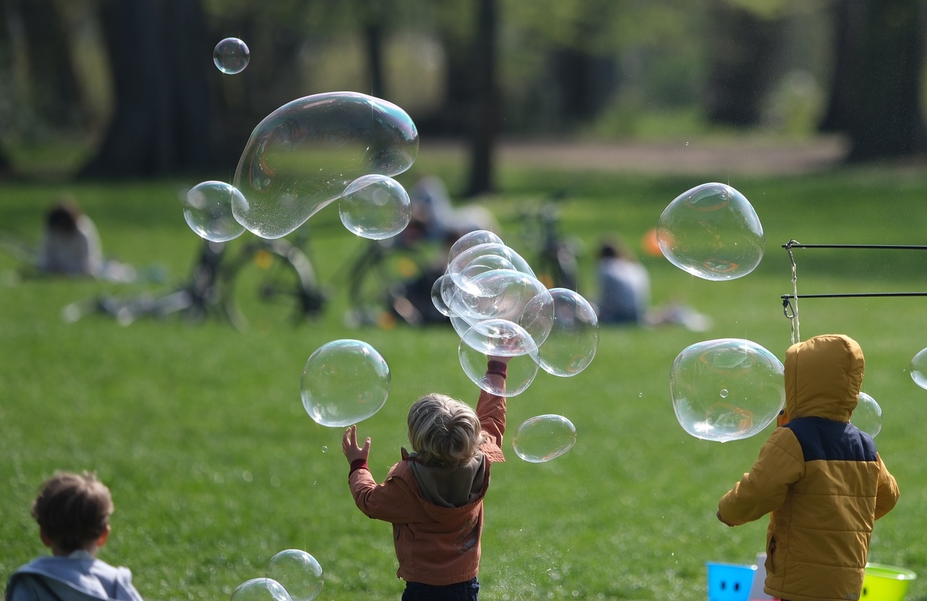 Kinder spielen mit Seifenblasen.