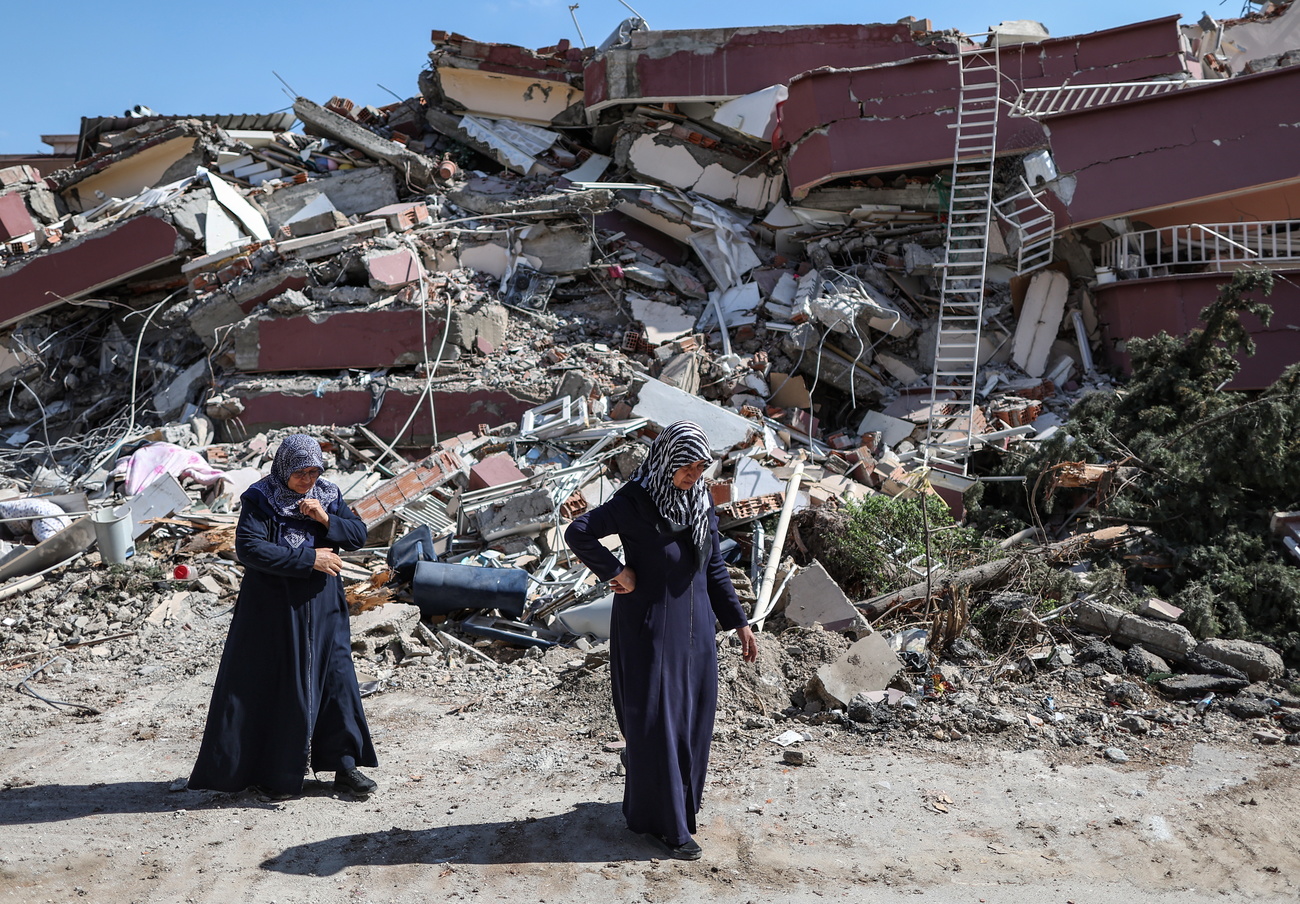 سيدتان تركيتان تمران من أمام الأنقاض