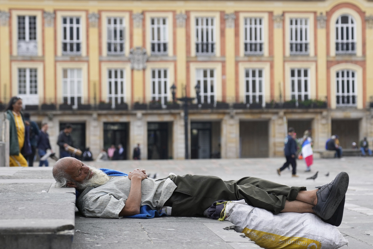 A homeless man sleeps on steps in the city