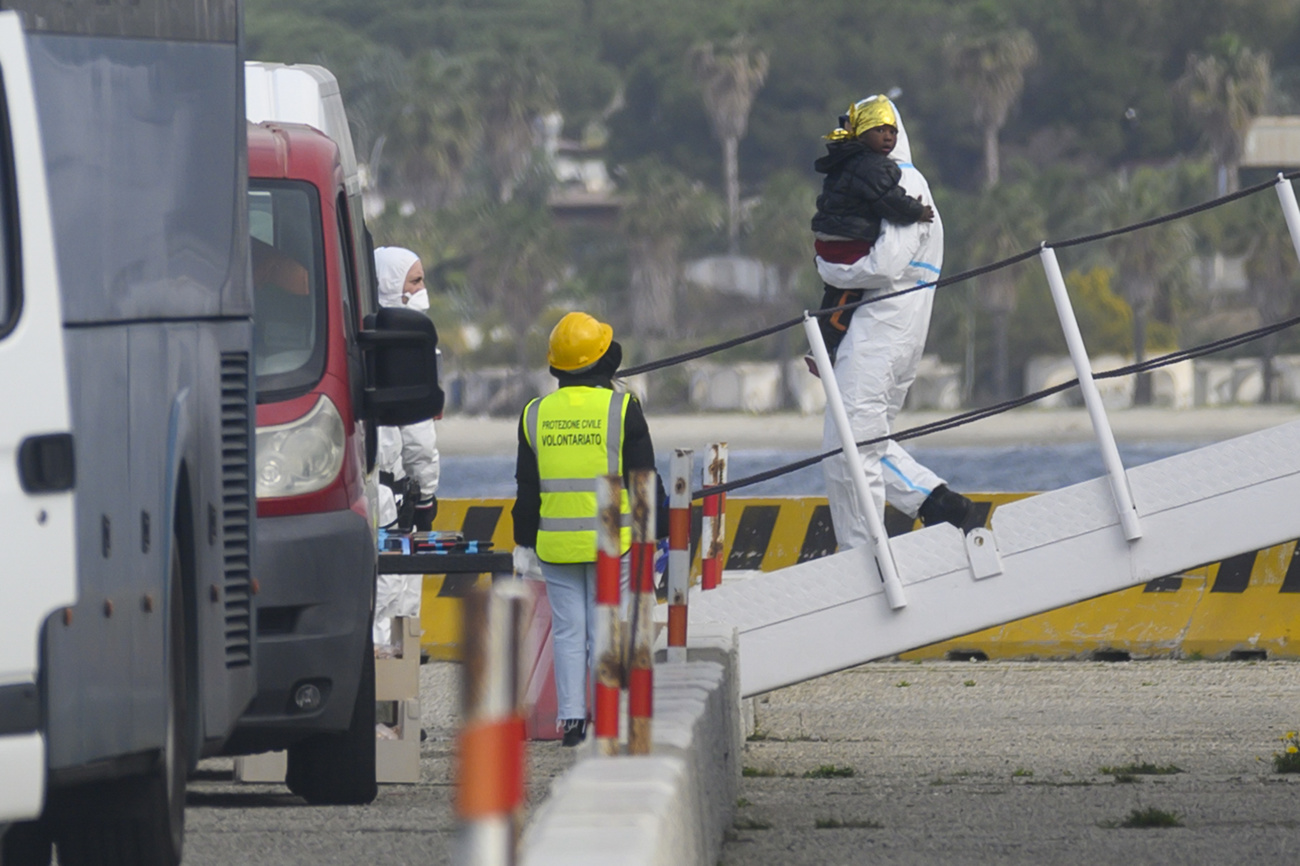 persona porta a terra da una nave un bambino