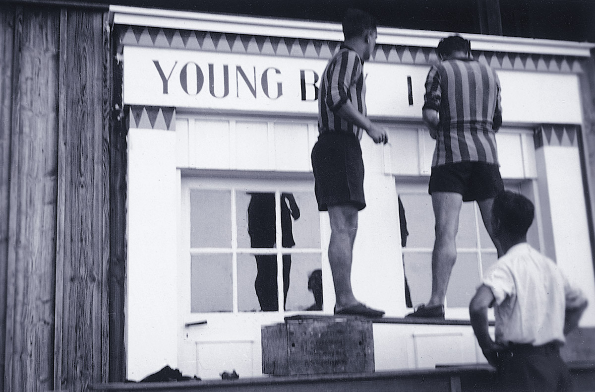Tres hombres poniendo el lema de Young Boys