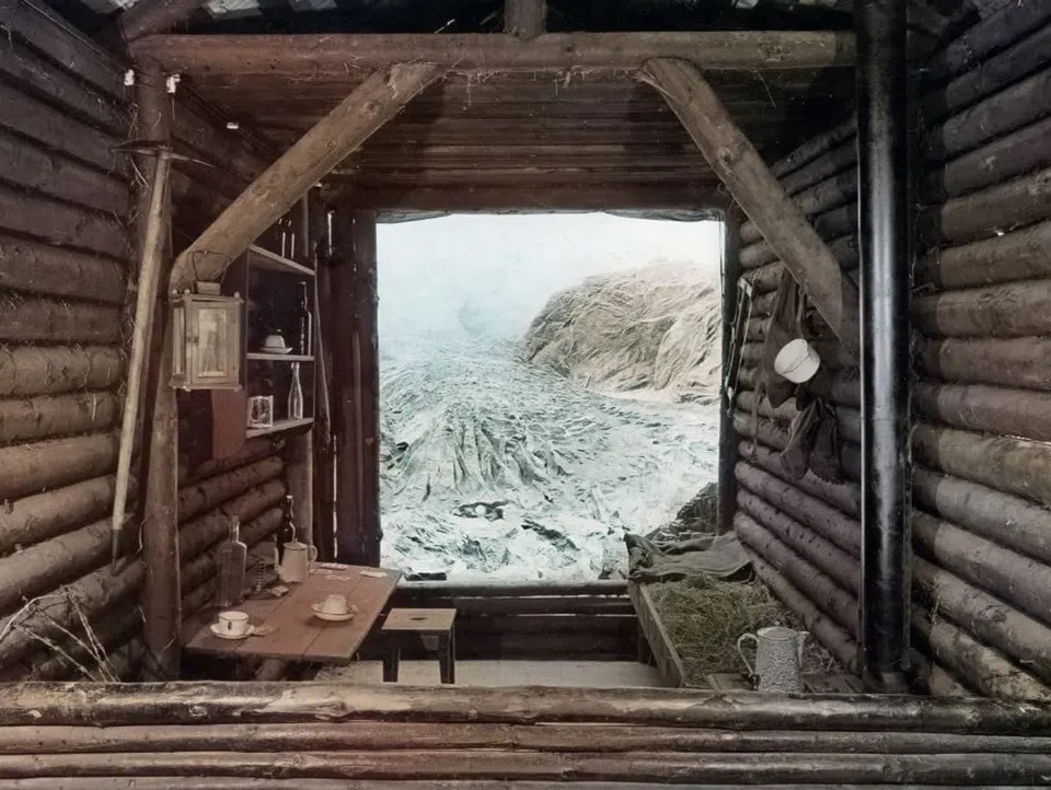 The inside of a wooden hut with a view of glaciers