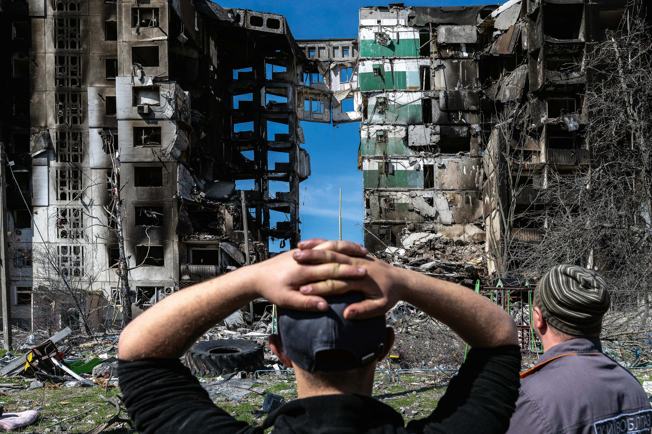 Image of onlookers of destroyed buildings in Ukraine