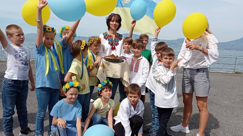 Bambini in riva al lago con palloncini gialli e blu