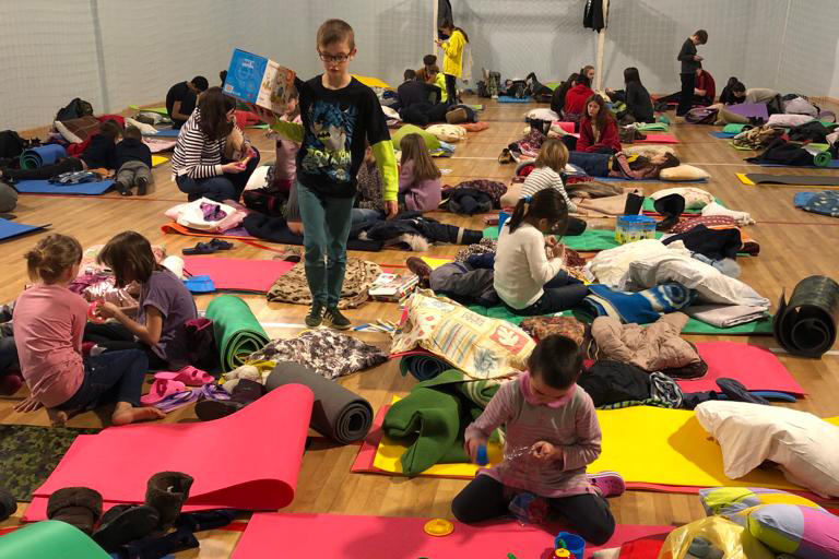 Niños durmiendo en un pabellón durante la evacuación