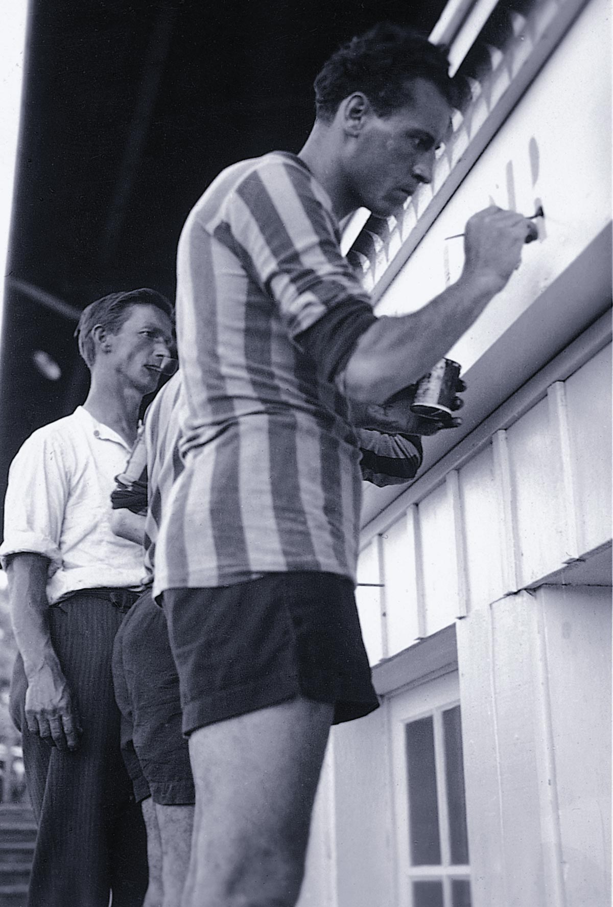 dos hombres escribiendo las letras del equipo en grande