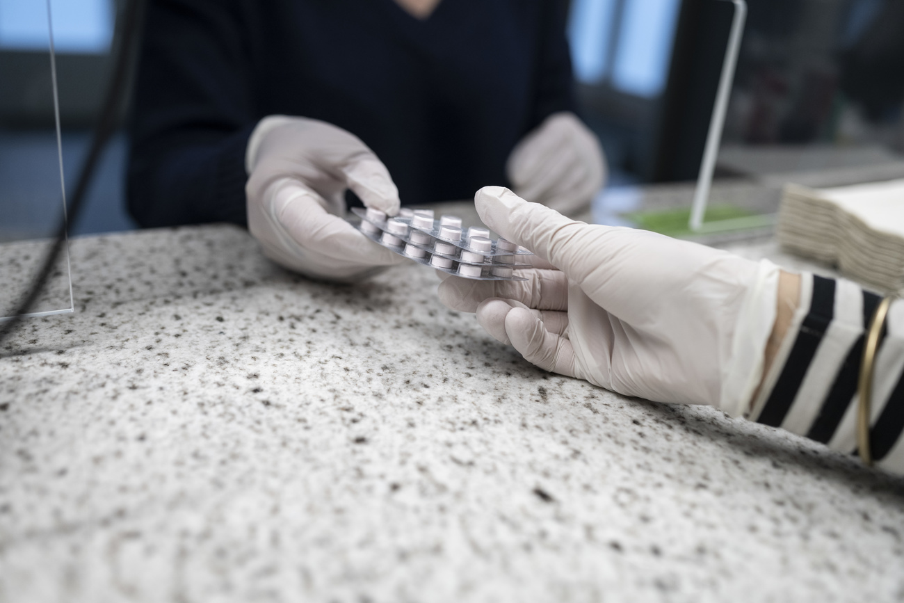 Photo of two people with surgical gloves holding methadone tables