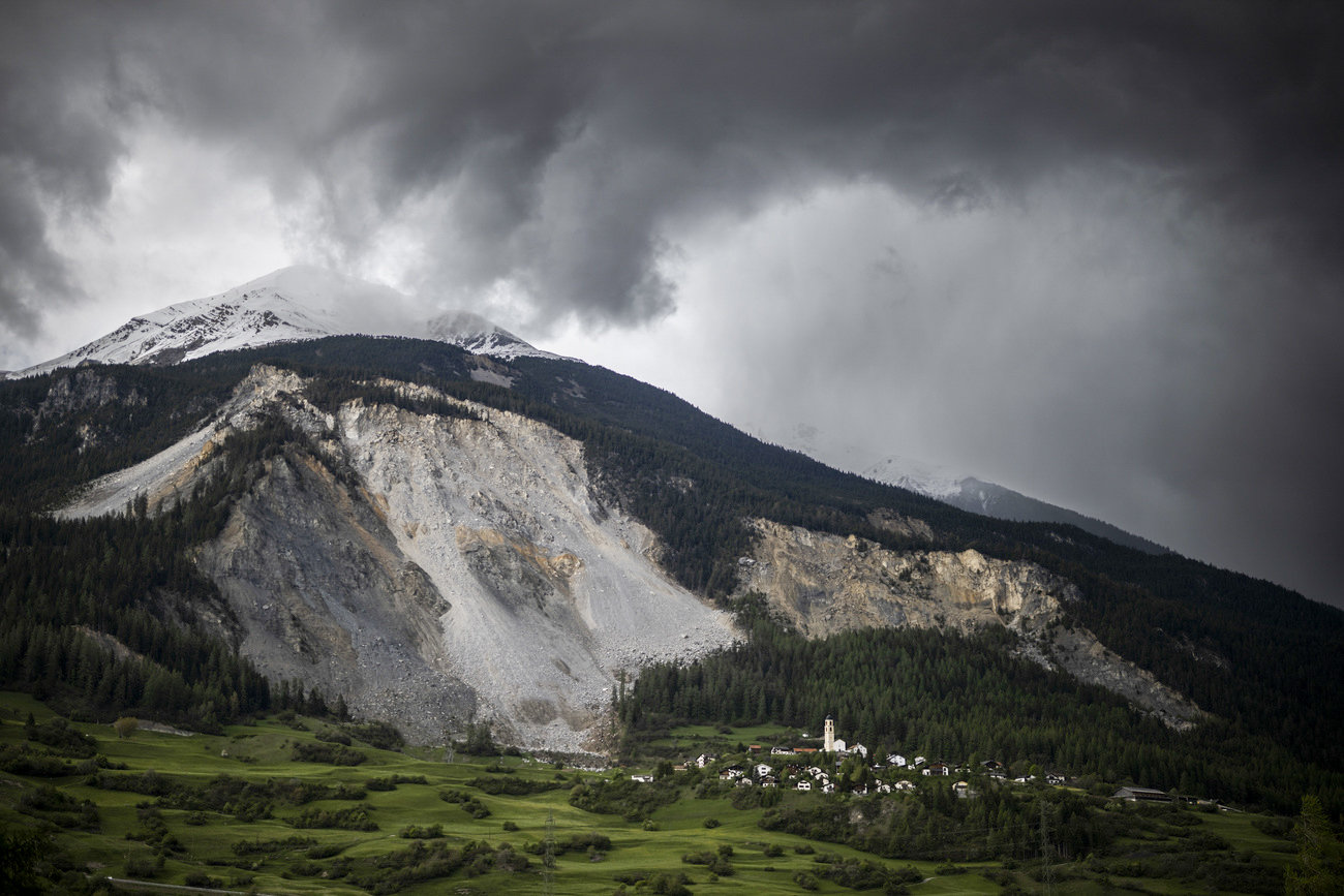 un villaggio sotto il pendio instabile di una montagna