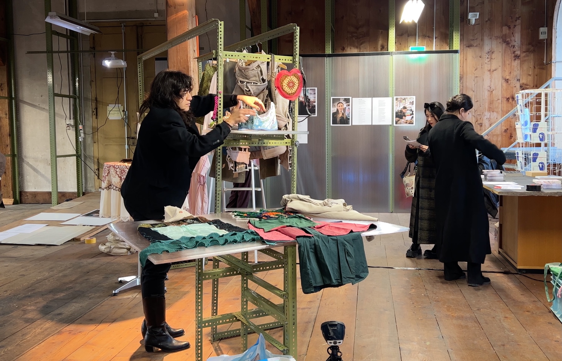 A woman putting clothes on display.