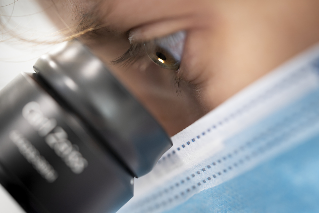 una persona guarda attraverso un microscopio