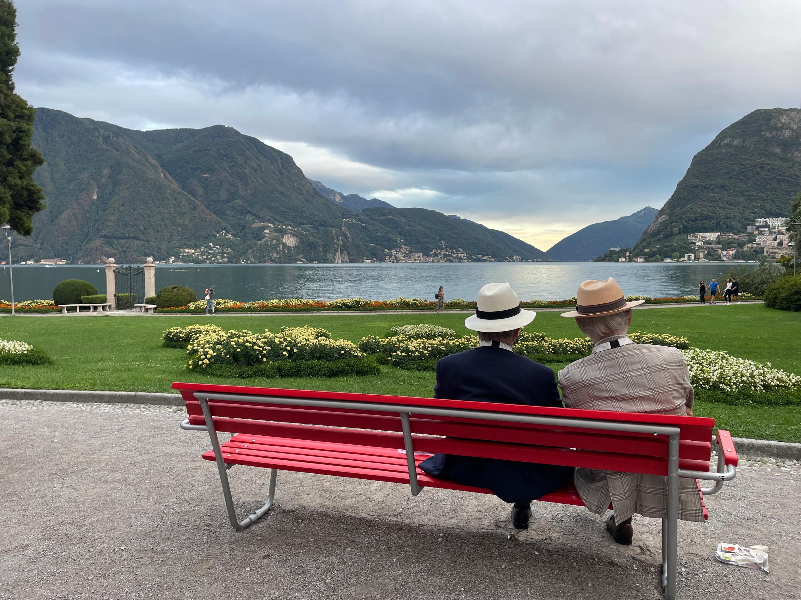 Two pensioners sitting on a bench overlooking the lake