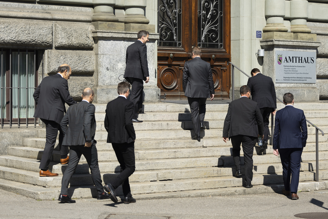 Männer in Anzügen laufen eine Treppe hoch