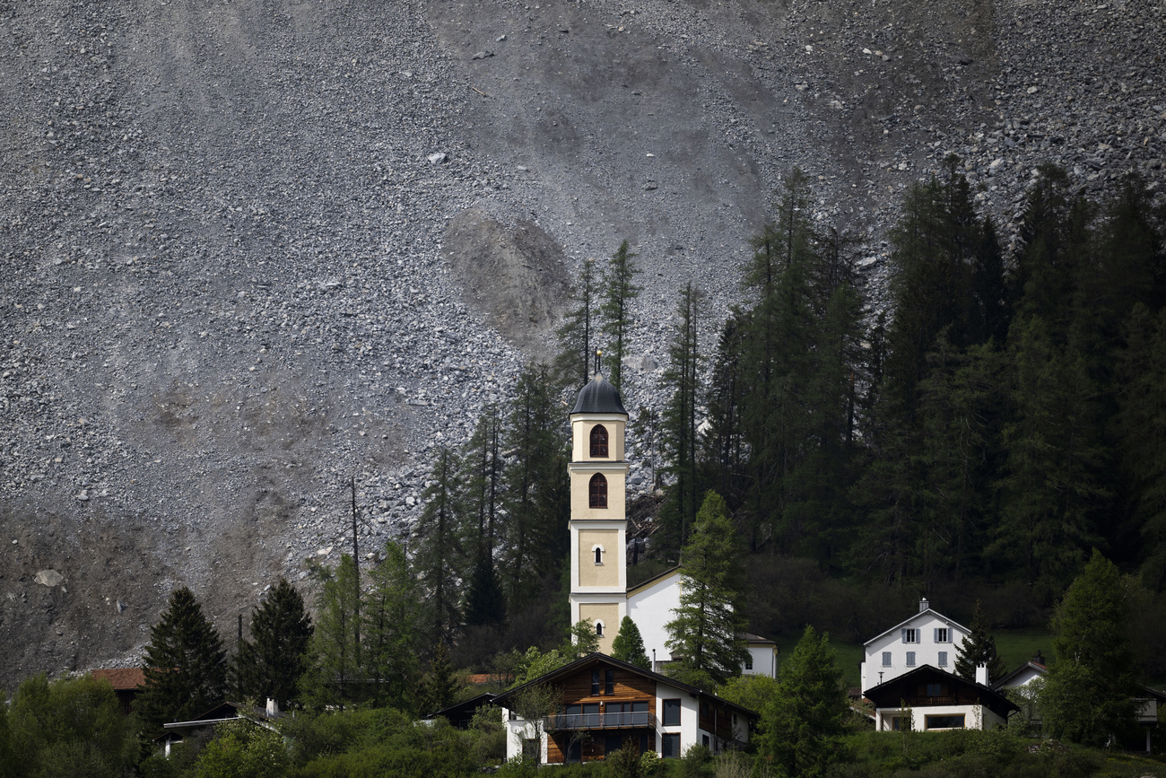 una chiesa ai piedi di un versante montano coperto di sassi