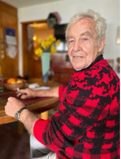 Older man in red and black checked shirt