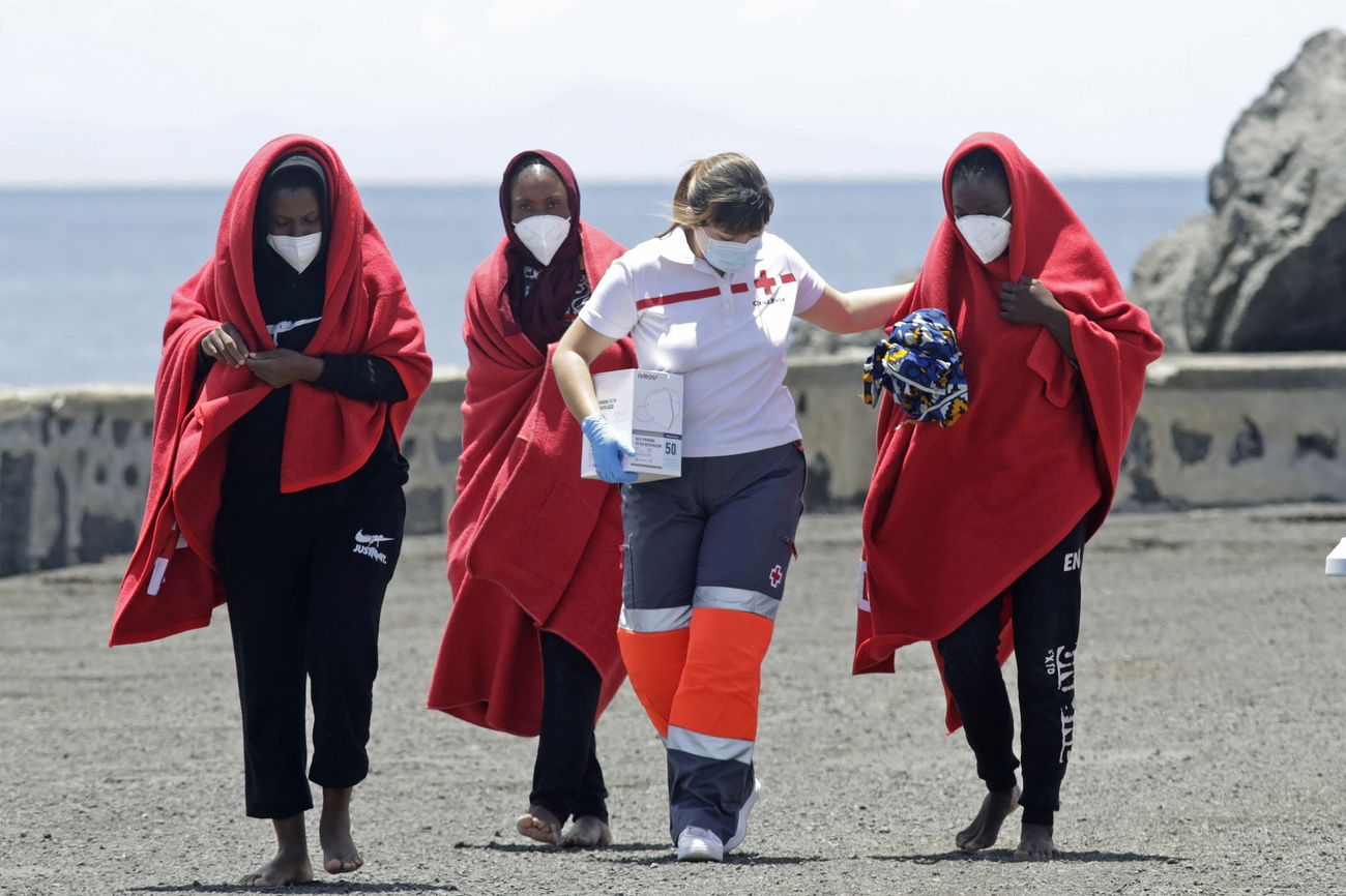 Photo of a woman helping three refugees