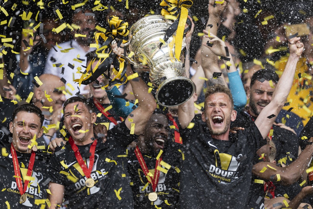 Fussballer mit Cuptrophäe in der Hand