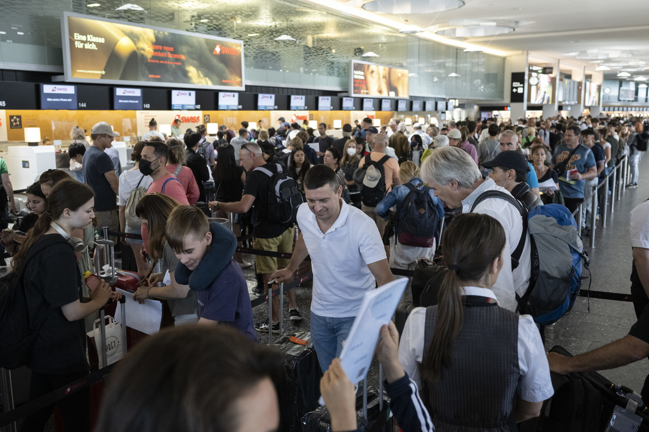 Photo of busy Zurich airport with many people waiting at the gates
