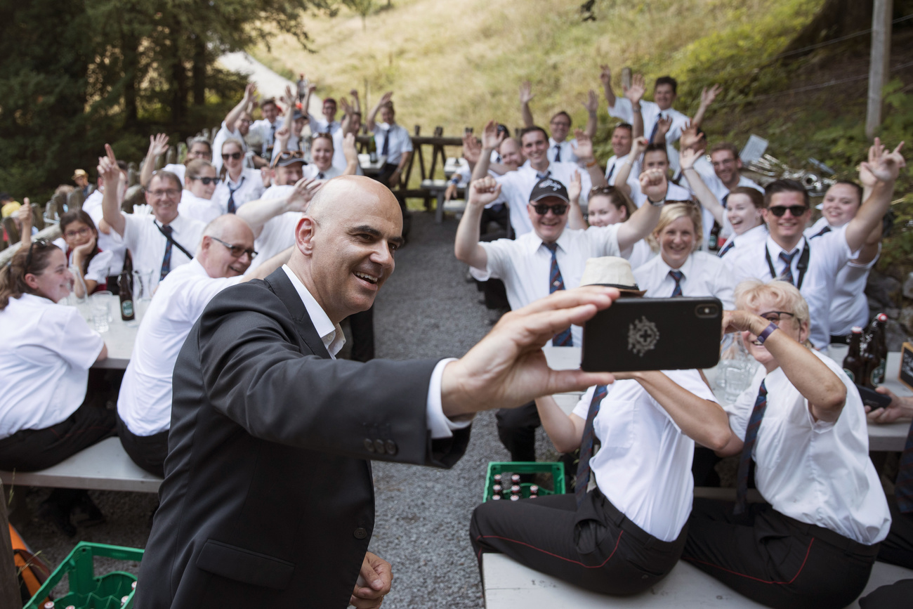 berset scatta un selfie assieme a un gruppo di persone vesite con una camicia bianca