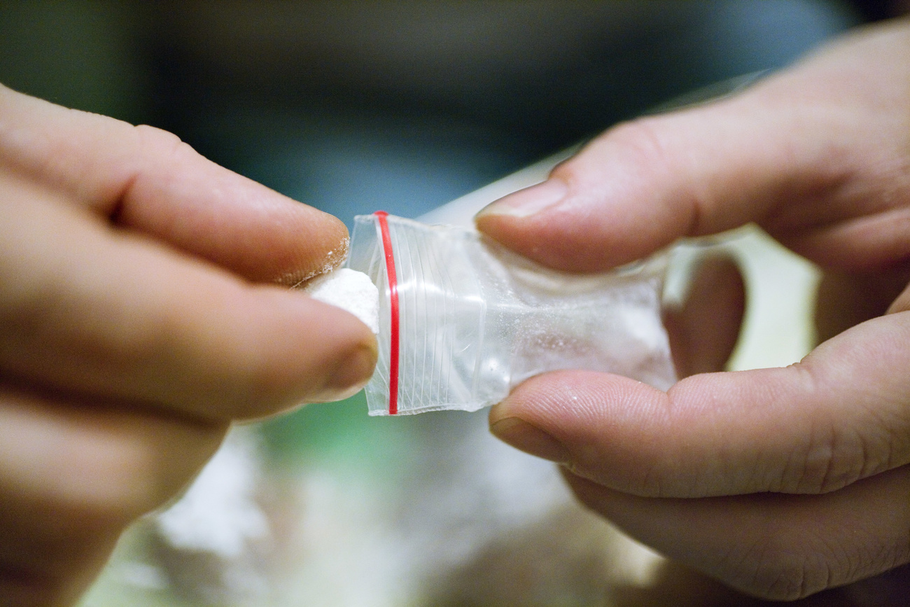 Photo of a person with a small bag of cocaine in their hands