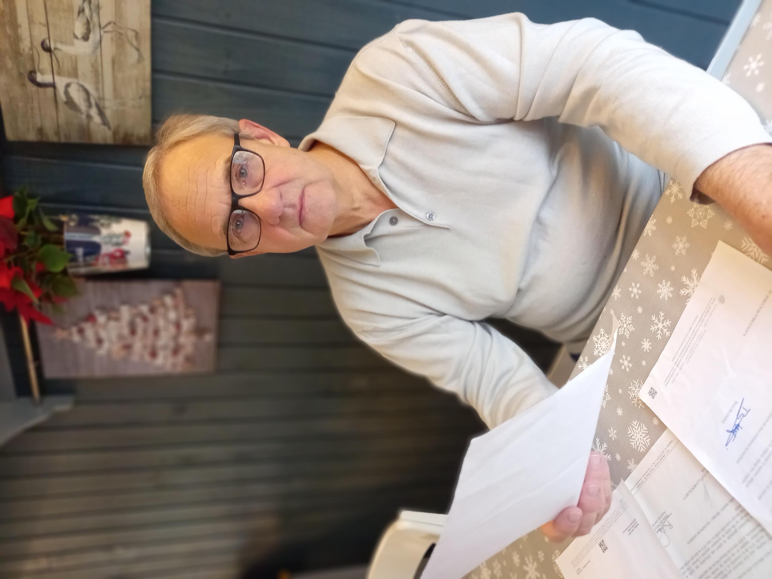 Joël Roux looks through various tax documentations for his case.