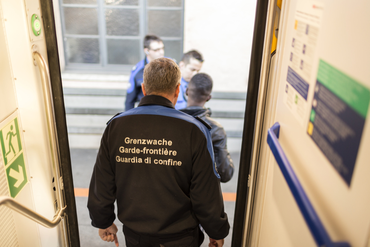 guardia di confine fotografata di spalle scende da un treno