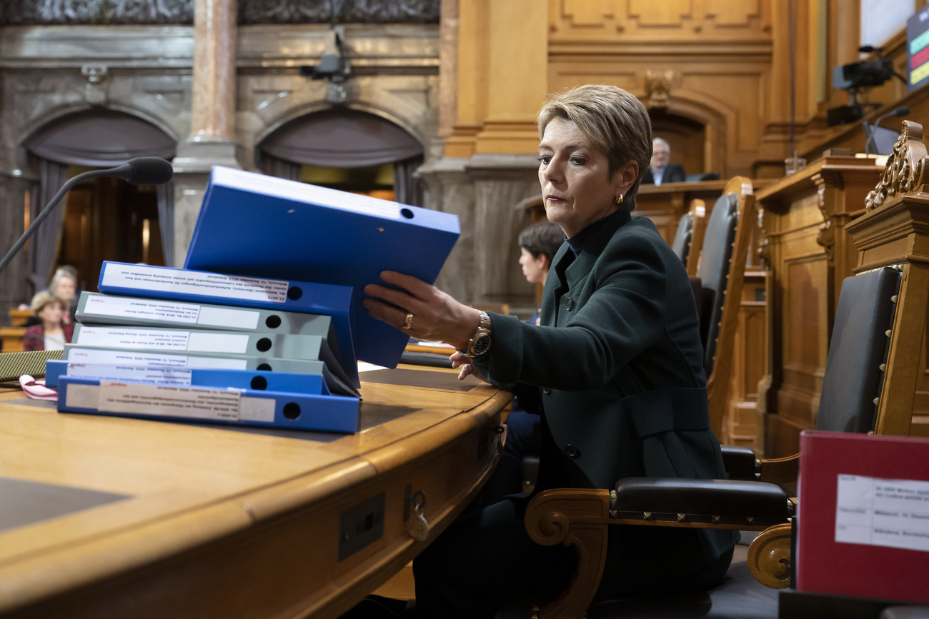 Finance Minister Karin Keller-Sutter with many folders in front of her. She could be called on to lead a complicated tax case.