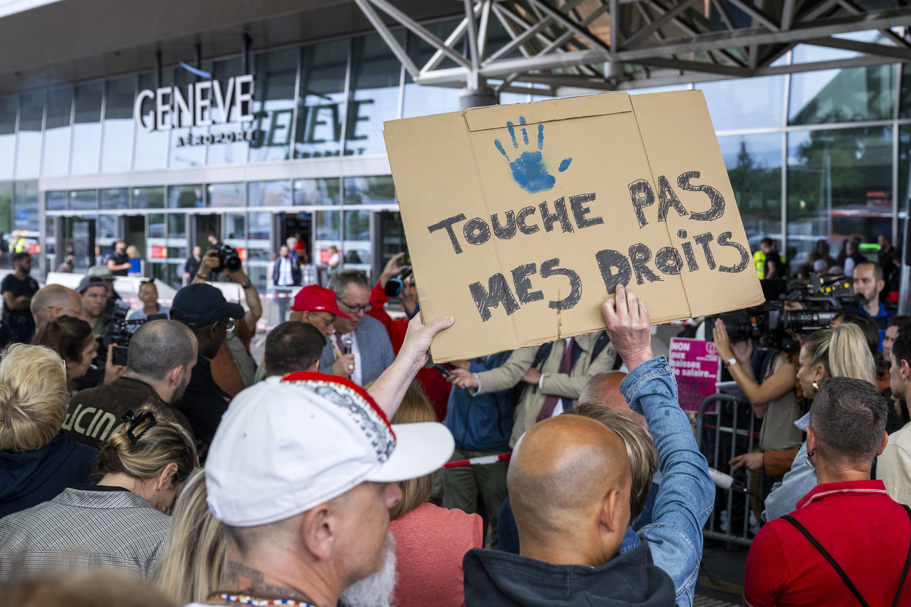 persone manifestano davanti a un aeroporto