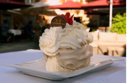 Grosse Dessert-Portion bestehend aus Schlagrahm und zwei Meringues mit dünnen Apfelscheiben garniert