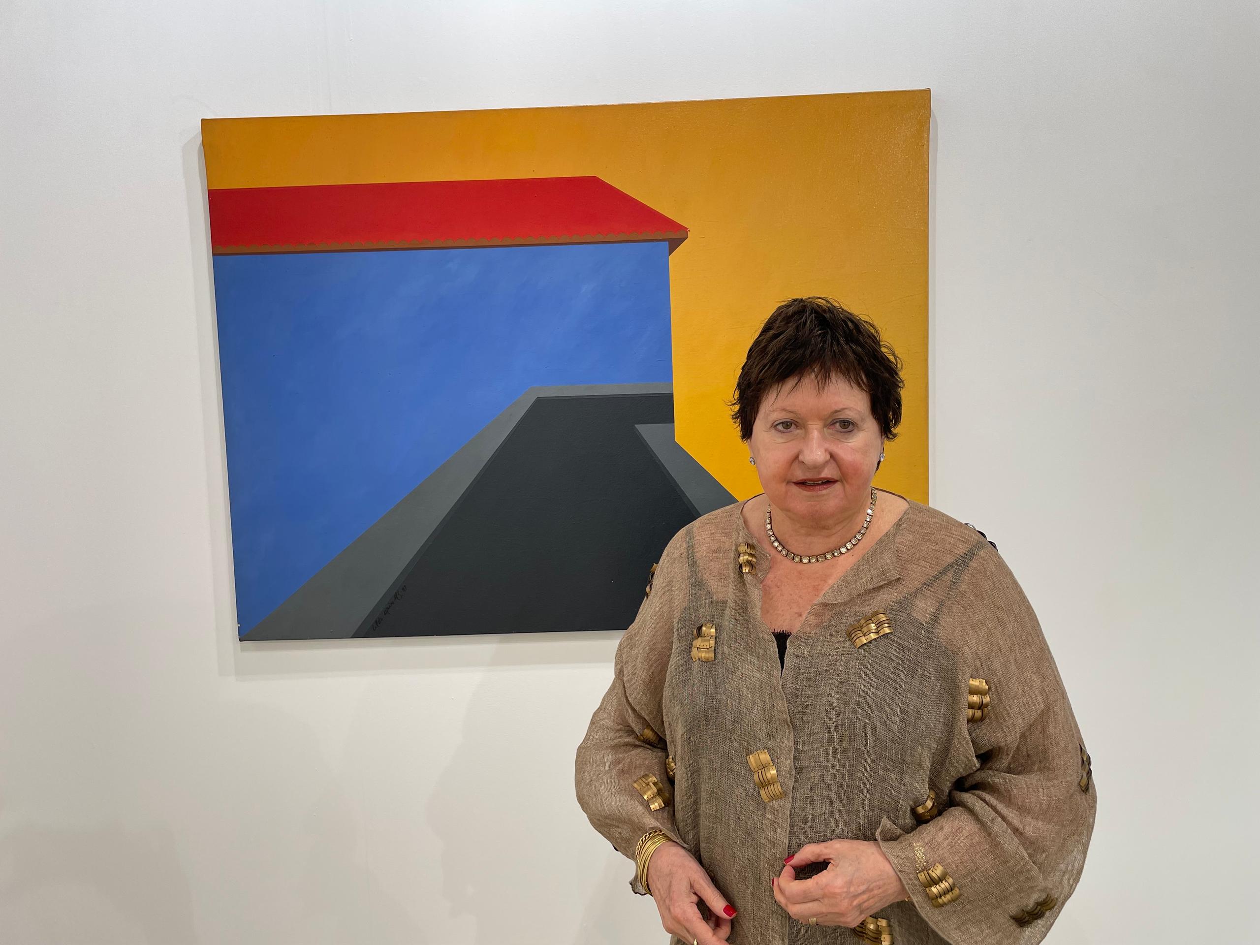 Brazilian gallerist Luisa Strina poses in front of a Cildo Meireles painting, in Basel