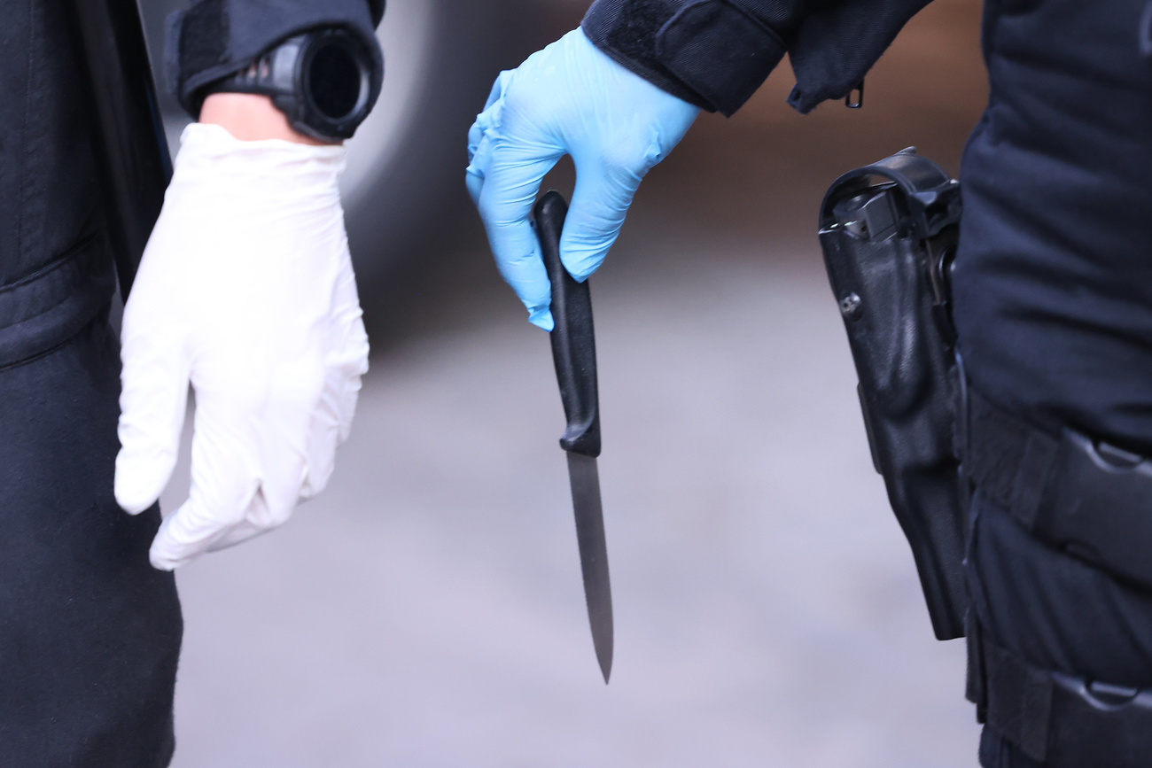 Le mani di un poliziotto con un coltello sequestrato,