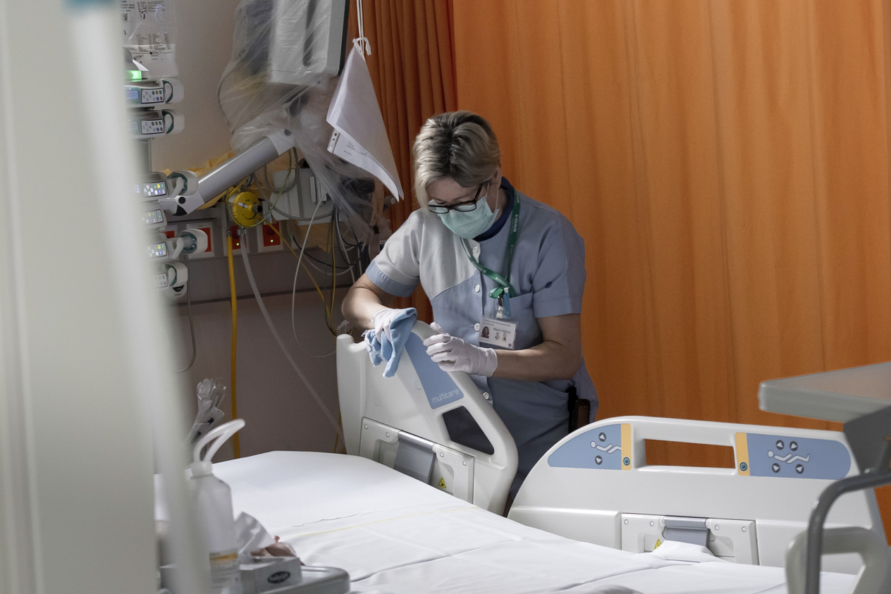 Covid-19 health worker cleans hospital bed.