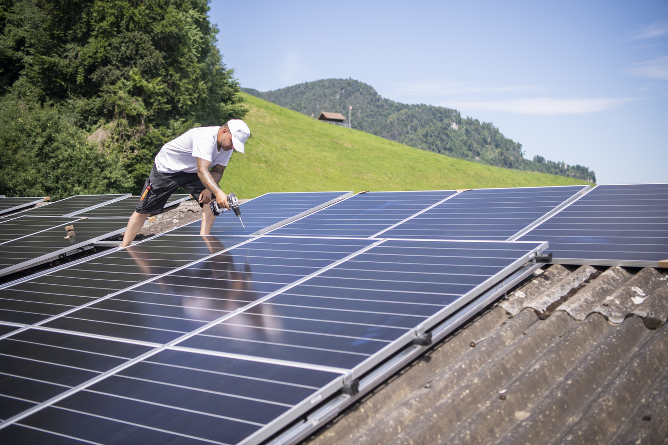 Man on a roof working on solar panels
