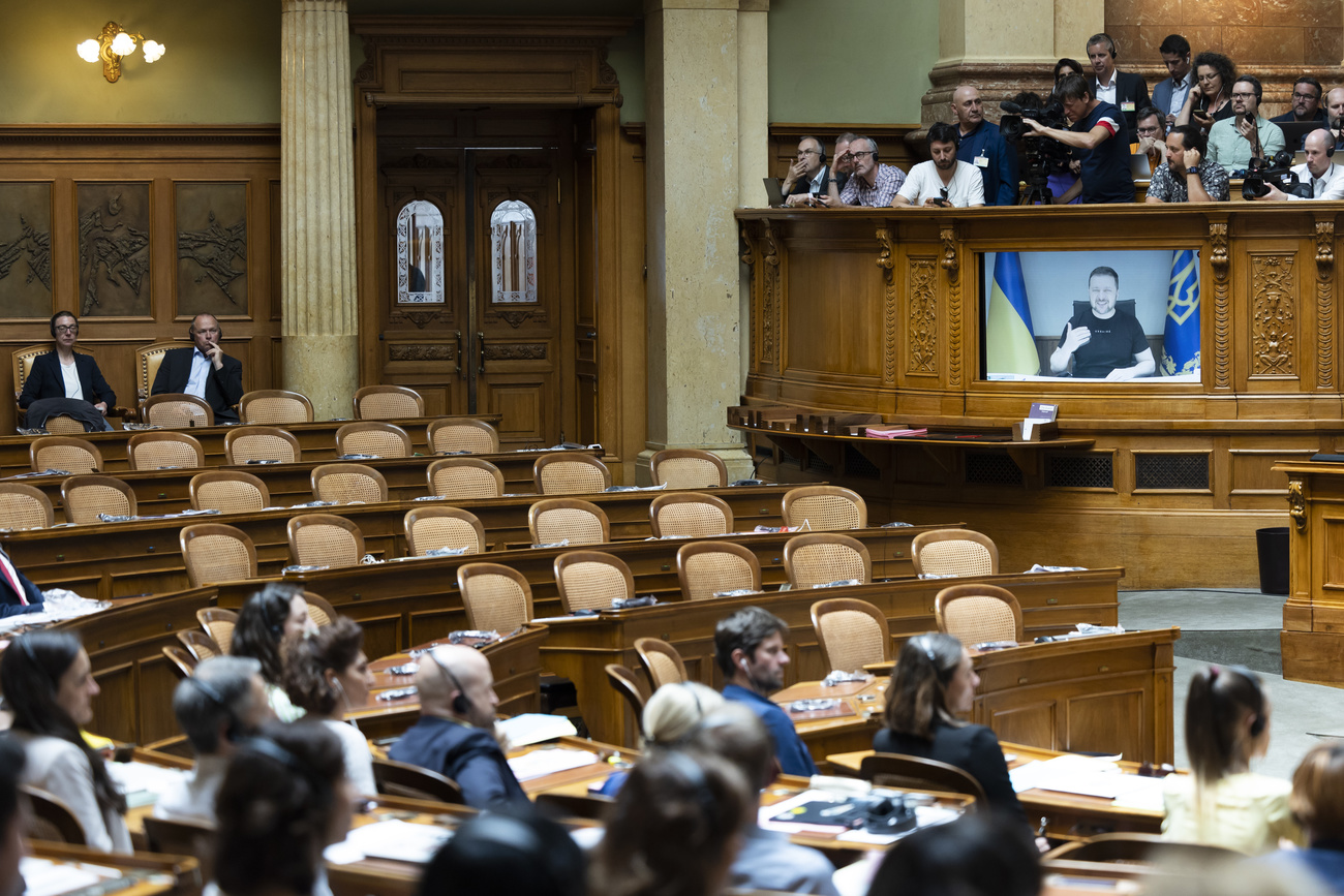 sedie vuote in aula e zelensky alllo schermo