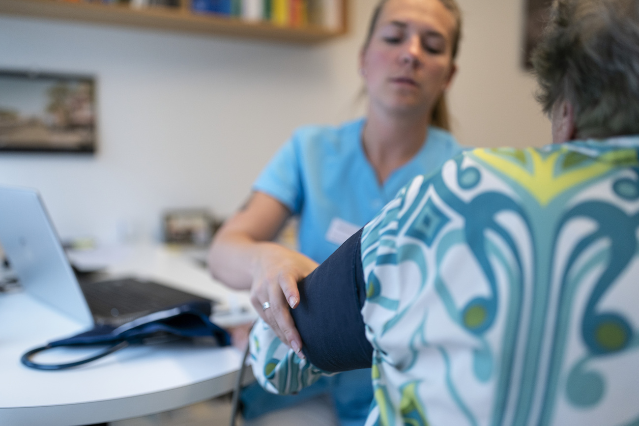 Uma enfermeira mede a pressão arterial, mas os custos do atendimento médico podem aumentar