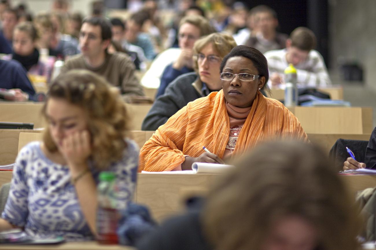 Photo of a university lecture with two young women listening and taking notes