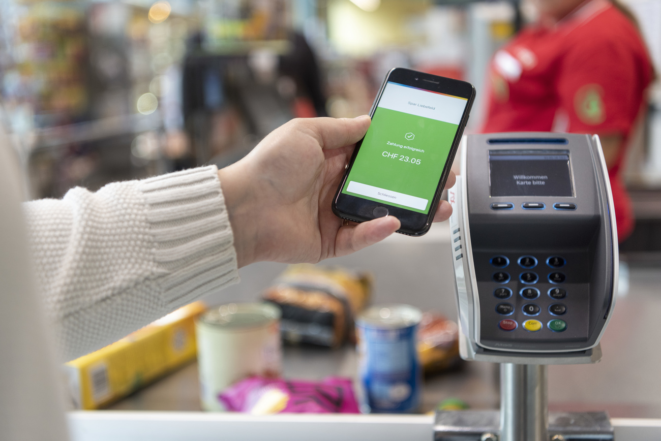 Un cliente utiliza Twint para pagar la compra en un supermercado.