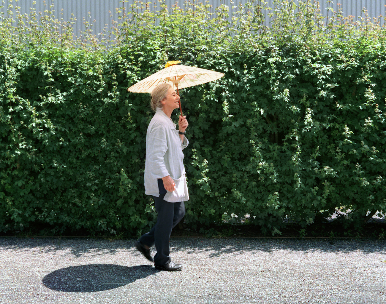 Flora Ruchat-Roncati cammina con un ombrello che la ripara dal sole