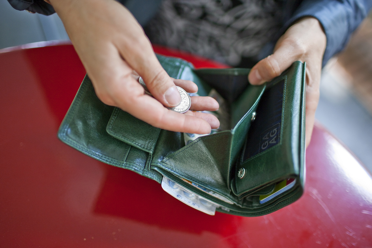 A woman holds her open purse in her hands.