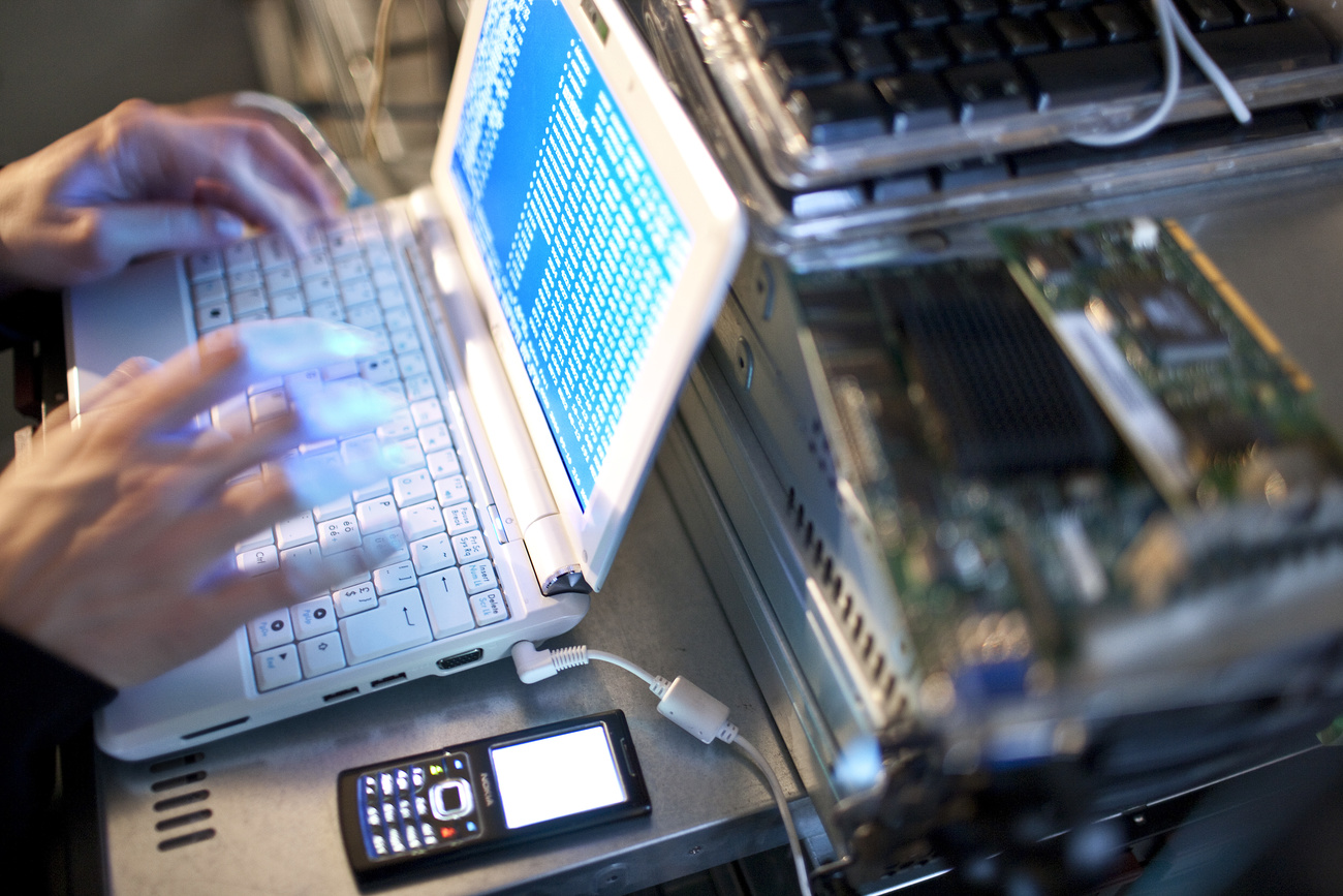 Picture of a person s hands typing on a computer connected to other devices