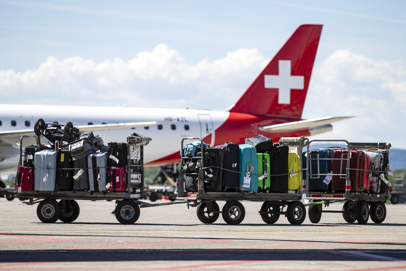 Zahlreiche Koffer werden am Flughafen Zürich zu einem Flugzeug transportiert