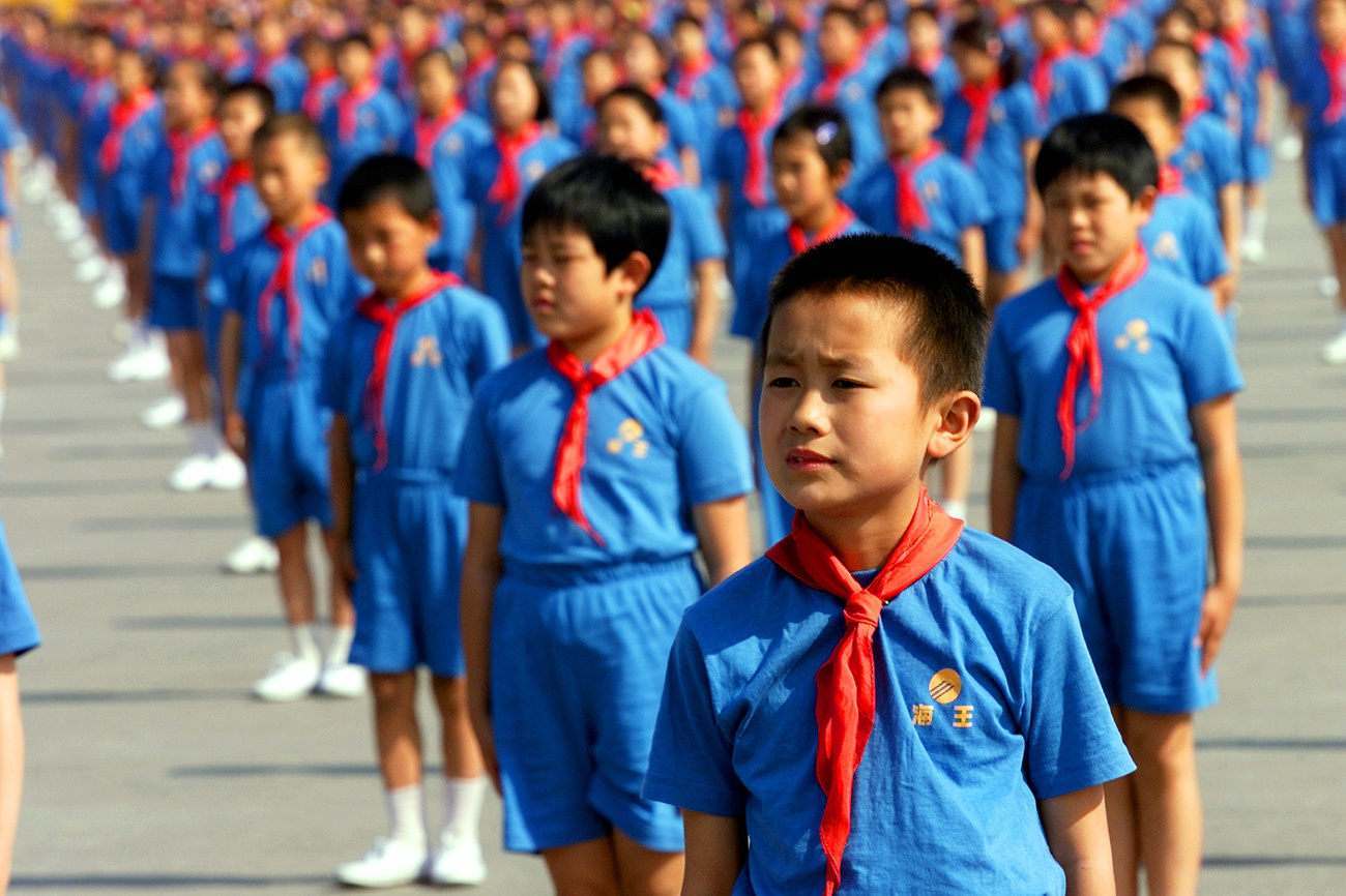 Des enfants chinois se tiennent en rang dans leurs uniformes scolaires.