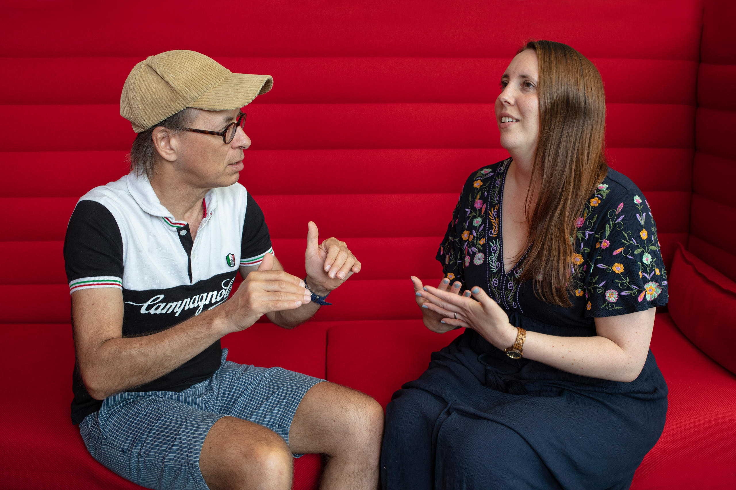 Renat Kuenzi und Isabelle Bannerman auf einem roten Sofa, diskutieren