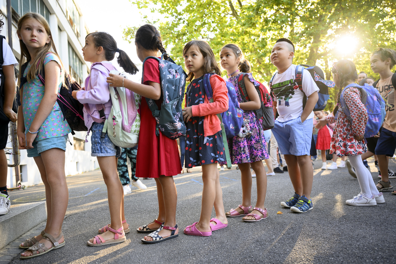 Gruppo di bimbi e bimbe tornano a scuola dopo la pausa estiva.
