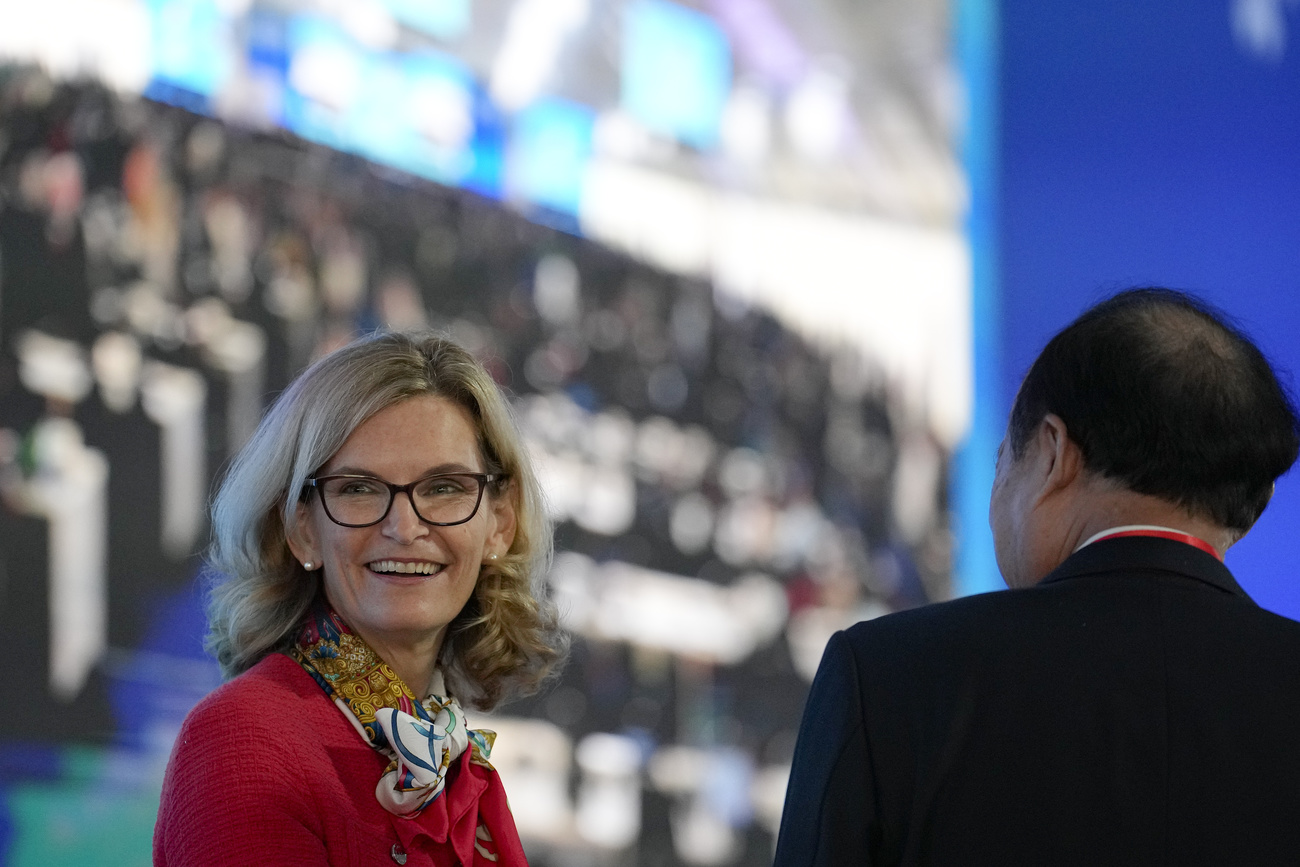 una donna e un uomo in una sala conferenze gremita