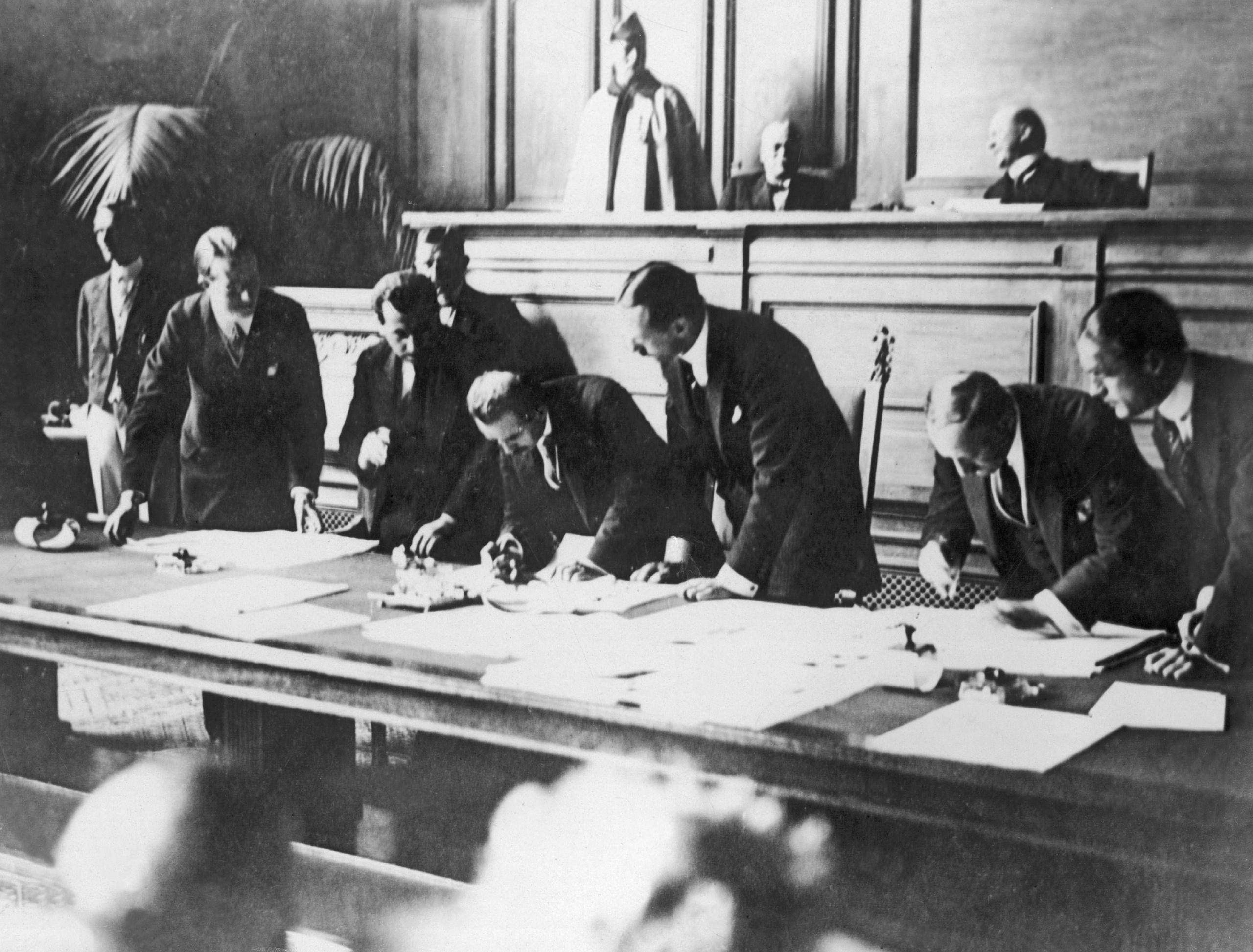 uomini in una sala mentre firmano un documento